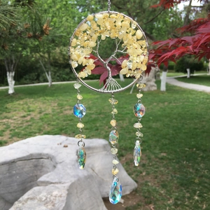 Detail of tree of life suncatcher with yellow crystals and prisms in outdoor light