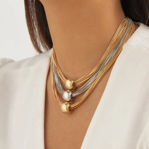 Detail of multilayer punk chain necklace with gold and silver geometric ball pendants