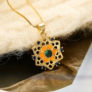 Detailaufnahme eines goldenen Sonnenblumen-Anhängers mit Emaille und Zirkon-Edelsteinen