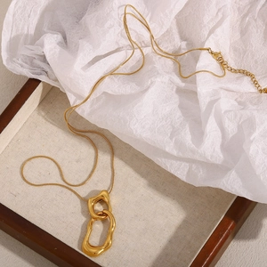 Detail of irregular double ring pendant in 18K gold finish on a fine snake chain necklace
