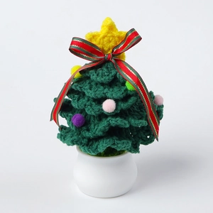 Handmade green crochet Christmas tree plant with star and colorful pom-poms in white pot
