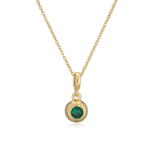 Detailed view of round gold necklace featuring a vibrant green gemstone centerpiece