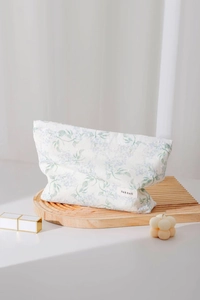 Dettaglio della borsa per cosmetici in cotone a fiori con motivi blu ed etichetta laterale