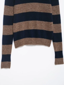 Detail of blue and brown striped knit sweater featuring ribbed hem and soft wool texture