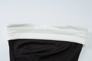 Detailed view of the black and white color block stitching on a slit bodycon dress