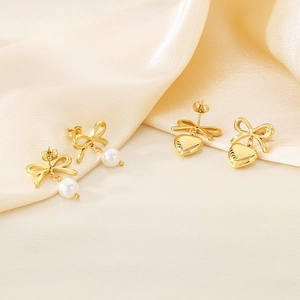 French style bow earrings with white pearl and gold heart pendants on silk fabric