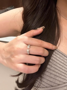 Close-up of S925 silver twist ring with pearls and crystals on a model hand