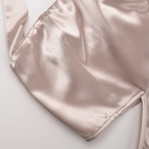 Vue macro détaillée montrant le tissu satiné champagne et les coutures de précision