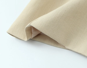 Gros plan sur la texture du tissu tissé kaki et les coutures fines du blazer