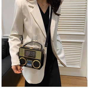 Detail of vintage radio-style acrylic handbag with gold hardware on a model