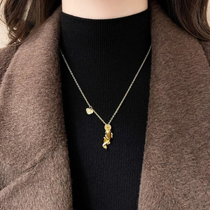 Nahaufnahme der goldenen Koi-Anhänger-Halskette mit feiner Kette auf einem Pullover