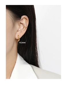 Macro detail of S925 silver golden irregular earrings and ear cuffs on a model
