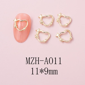 Macro shot of 11x9mm gold heart nail charm with cross details on a pink manicure