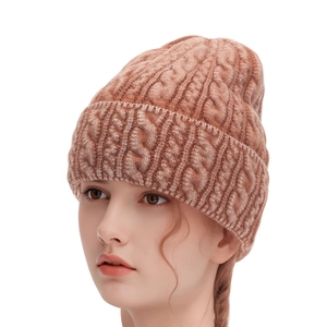 Detailed knit texture of caramel brown cable-knit beanie with turn-up cuff design