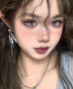 Close-up of sparkling face rhinestones and liquid metal earring for music festivals