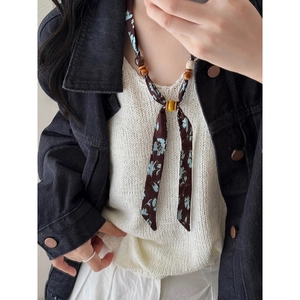 Close-up of ethnic style fabric chiffon and wooden beaded necklace on a model