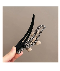 Détail de la pince à cheveux chiot avec tissu à carreaux noir et blanc et ours en peluche