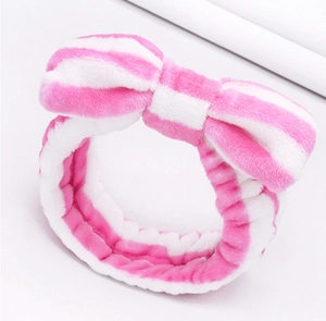 Detailed view of plush pink and white striped spa headband with a large bow decoration