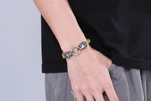 Detail of lion head bracelet in antique silver and gold on a male wrist model