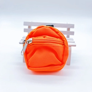 Detailed view of an orange mini canvas backpack keychain with a silver zipper