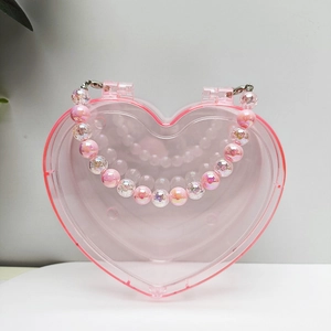 Detailansicht einer rosa herzförmigen Perlen-Aufbewahrungsbox mit transparentem Design