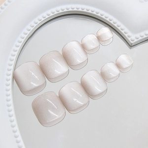 Light coffee cat-eye press-on toenails in a minimalist shimmering finish on a mirror tray
