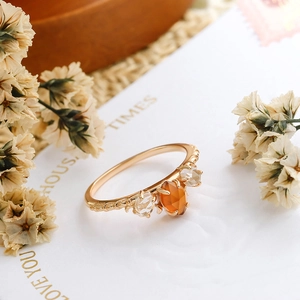 Detalle de anillo en plata 925 bañada en oro con granate naranja y banda trenzada retro