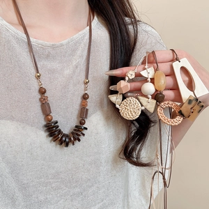 Close-up of bohemian wooden bead necklace featuring woven rattan and natural shell textures