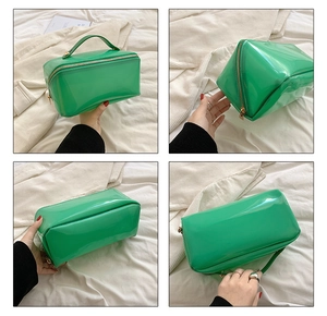 Detailansicht der smaragdgrünen PVC-Kosmetiktasche mit Goldreißverschluss und Griff