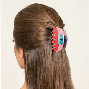 Cartoon UFO hair claw clip in red and pink securing a stylish half-up hairstyle