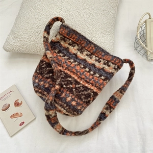 Detail of plush knit shoulder bag featuring retro geometric stripes and soft texture