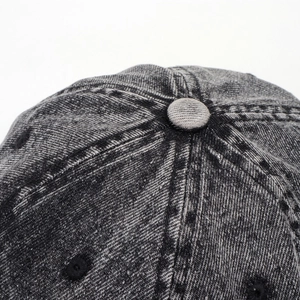 Macro detail of acid wash denim baseball cap crown with stitched seams and eyelets