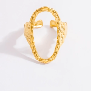 Detail of golden adjustable ring featuring a unique irregular textured surface and metal shine