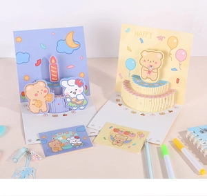 Detail showing a 3D pop-up birthday card with a cute cartoon bear and cake