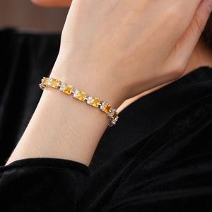 Detalle de pulsera de plata con circonita amarilla cuadrada y diamantes blancos en muñeca