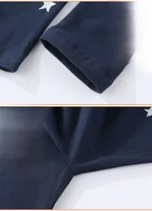 Macro detail of navy knit cotton girl leggings featuring sequin star and reinforced stitching