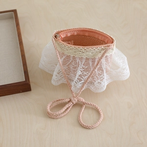Detail of pink straw crossbody bag with white lace ruffle and braided shoulder strap
