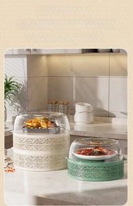 Close-up of stackable food covers with geometric hollow design in cream and vintage green