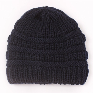 Close-up of thick navy blue knit pattern and elastic ribbed texture on winter baby hat