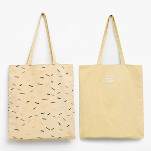Close-up detail of a dual-use canvas tote bag with ginger yellow and rain pattern design