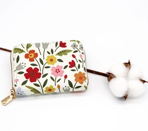 Close-up of small floral accordion card holder with gold metal zipper and PU leather texture