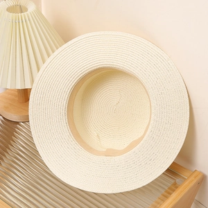 Close-up of cream woven straw sun hat with detailed braided texture and wide brim