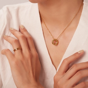 Detail of 18K gold plated necklace with zircon hollow pendant and chain ring on model