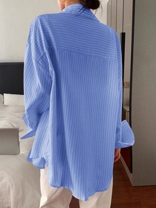 Detail view of the back design on a casual blue pinstriped long-sleeve shirt for women