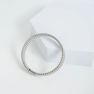 Bracciale in rete di acciaio inossidabile lucido con fibbia su supporto geometrico bianco
