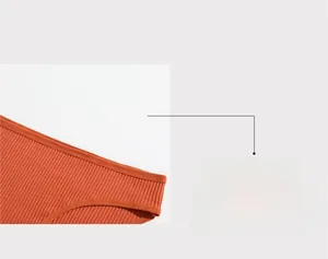 Detail of orange ribbed cotton panties featuring a mid-waist cut for women