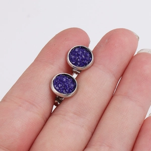 Macro view of 8mm round blue glitter stud earring with silver stainless steel base