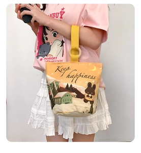 Detail of canvas bucket bag with cute rabbit print and Keep Happiness slogan shown on model