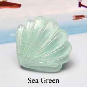 Détail d'accessoire coquillage en résine pailletée vert d'eau avec texture ondulée