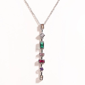 Detailed view of long silver necklace with geometric colorful gemstone pendant